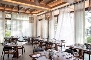 a restaurant with tables and chairs and large windows at Jumeirah Al Naseem Dubai in Dubai