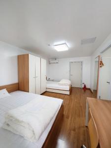 Habitación blanca grande con 2 camas. en Byulbam Guesthouse en Gwangju