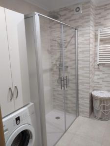 a shower stall in a bathroom with a washing machine at Apartamento primera línea playa d samil in Vigo +16 photos