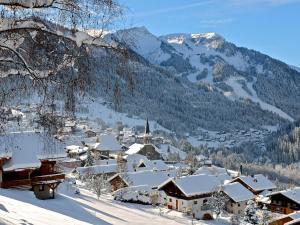 un village recouvert de neige avec des montagnes en arrière-plan dans l'établissement Le Hameau des 4 Saisons, à Châtel