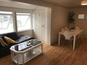 a living room with a couch and a table at Frimannsbuda in Selje