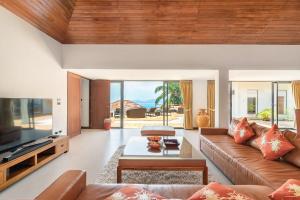a living room with a couch and a tv at 5 Bedroom Sea View Villa Bubbles SDV376 By Samui Dream Villas in Mae Nam