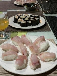dwa talerze mięsa i sushi na stole w obiekcie Ecoresort Sumba Dream w mieście Rindi