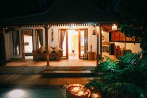 een woonkamer met een bank in een huis bij Private Villa with nature atmosphere by Pondok Dino in Ubud