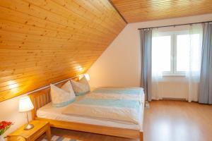 Schlafzimmer mit einem Bett mit Holzdecke in der Unterkunft Haus Fünfschläfer in Dreschvitz