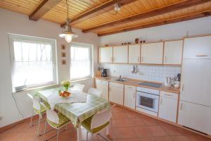 a kitchen with a table and chairs in a kitchen at Haus Fünfschläfer in Dreschvitz