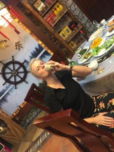 a woman sitting in a chair drinking a drink at Huangyaguan Great Wall Li Bo Home Hotel in Jixian