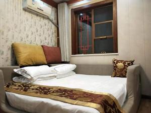 a bedroom with a bed with pillows and a window at Huangyaguan Great Wall Li Bo Home Hotel in Jixian