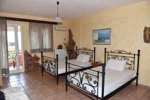 two beds in a room with a balcony at Aphrodite studios in Loutra Edipsou