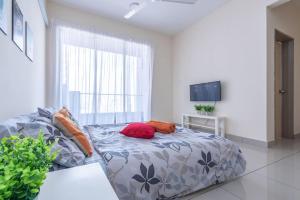 una sala de estar con una cama con almohadas. en PV21 Setapak Wangsamaju Melawati 15 min to KLCC- 2ROOM, en Kuala Lumpur