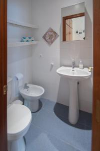 La salle de bains blanche est pourvue de toilettes et d'un lavabo. dans l'établissement Apartment Cadiz´s Angel, à Cadix