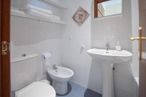 La salle de bains blanche est pourvue de toilettes et d'un lavabo. dans l'établissement Apartment Cadiz´s Angel, à Cadix
