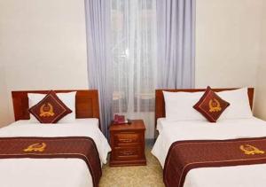 a hotel room with two beds and a window at Victor Hotel in Tiền Tiệp
