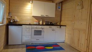 una cucina con elettrodomestici bianchi e un tappeto sul pavimento di Qubalonka Saunarium Bory Tucholskie a Karsin