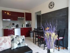 cocina y sala de estar con mesa y sillas. en Charmant 2 pièces à 500 m des plages et du centre, en Cabourg