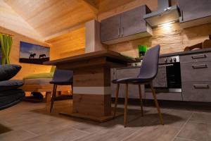 a kitchen with a counter and chairs in a room at Almhuette MeineZeit in Donnersbachwald