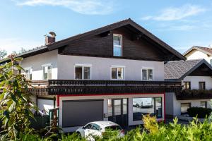 a house with a car parked in front of it at Ferienwohnung EVA in Seekirchen am Wallersee
