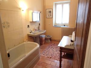 a bathroom with a tub and a toilet and a sink at France Petit Château in Loué