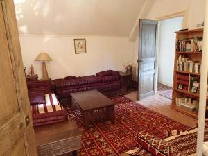 uma sala de estar com um sofá e uma mesa em France Petit Château em Loué