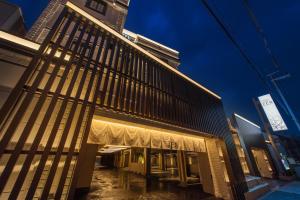 un edificio con una fachada iluminada por la noche en HOTEL ZEN HIRANO (Adult Only) en Osaka