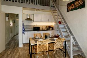 a kitchen and dining room with a table and a staircase at Les Coquillages in La Guérinière