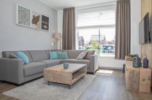 a living room with a couch and a coffee table at Bosruiter De Koog - Texel in De Koog