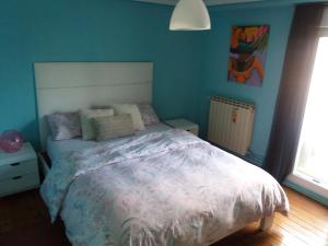 1 dormitorio con 1 cama grande y paredes azules en Kasa Karmen en Fuenmayor