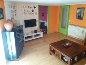 a living room with a table and a tv at Kasa Karmen in Fuenmayor