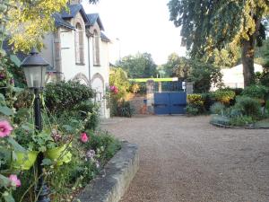 a garden with flowers and a house with a street light at France Petit Château in Loué