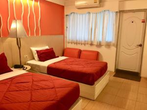 1 dormitorio con 2 camas, lámpara y ventana en Highway Hotel en Chiang Mai