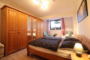 una camera da letto con un letto grande e armadi in legno di Ferienwohnung Nana a Braunlage