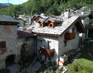 una antigua casa de piedra con balcones de madera en el techo. en B&B L'Abric - Posto Tappa GTA, en Limone Piemonte