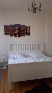 - un lit blanc dans une chambre avec une photo sur le mur dans l'établissement FEWO Gerdi und Hanne, à Schenefeld