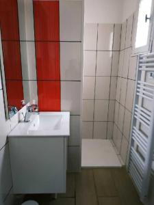 a white bathroom with a sink and a shower at appartement avec terrasse in Aurillac