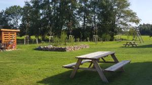 dos mesas de picnic en un parque con parque infantil en Emsgold en Oberlangen