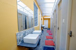 a bathroom with three sinks and a row of mirrors at Roambay in Mysore