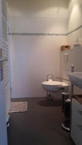 La salle de bains blanche est pourvue d'un lavabo et d'une baignoire. dans l'établissement FEWO Gerdi und Hanne, à Schenefeld