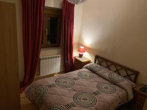 1 dormitorio con cama, cortinas rojas y ventana en Casa Dono Sanabria, en Cobreros