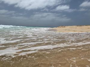 a sandy beach with waves on the ocean at Paradise Cape Verde in Santa Maria