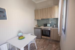 a small kitchen with a white table and a table and chairs at Aura central apartments in Argostoli