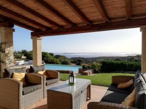 a patio with wicker chairs and a table with a view at La Sima villa con piscina vista mare San Pantaleo Sardegna in San Pantaleo