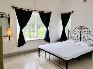 a bedroom with a bed and a window at Preyoshi in Bolpur