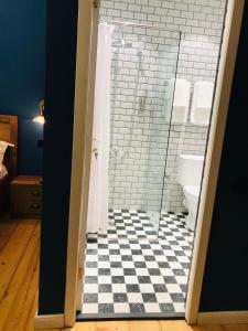 La salle de bains est pourvue d'une douche et d'un sol en damier noir et blanc. dans l'établissement Apartment Riverside, à Koutaïssi