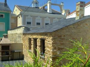 Una casa de piedra con una cruz encima. en Apartamentos Turisticos As Cetareas, en Rinlo