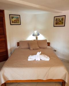 Una bata blanca en una cama en un dormitorio en Hotel Valle Verde, en El Valle de Antón