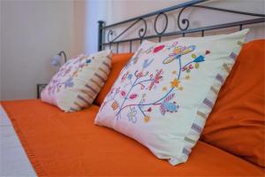 2 Kissen auf einem Bett mit orangefarbenem Laken in der Unterkunft Casa di Marina in Viareggio
