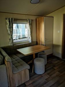 a dining room with a table and chairs and a window at Pebble Bay Retreat in Milford on Sea