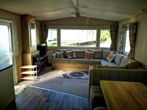 a living room with a couch and a table at Pebble Bay Retreat in Milford on Sea