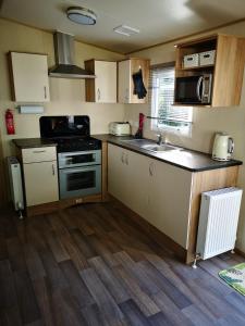 een kleine keuken met een fornuis en een magnetron bij Pebble Bay Retreat in Milford on Sea