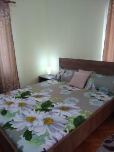 a bedroom with a bed with white flowers on it at Olimpia Apartments in Alba Iulia